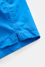 Nahaufnahme der blauen MC2 Saint Barth Badeshorts 'Lightning Pantone' aus recycelter Microfaser, Fokus auf Saum und Seitenschlitz, Regular Fit, elastischer Bund.