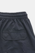 Close-up rear view of 04651/ A trip in a bag Swim shorts 'Mono Seersucker' navy showing elasticated waistband and back pocket with flap.

<p>Perfect for your next summer holiday: With their design in seersucker look, these swim shorts by 04651/ A TRIP IN 