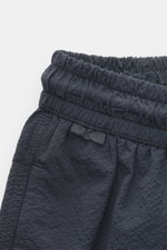 Close-up front-side view of navy swim shorts with elastic waistband in seersucker fabric, featuring 04651/ A trip in a bag Swim shorts 'Mono Seersucker' navy. Perfect for your next summer holiday: With their design in seersucker look, these swim shorts by