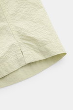 Close-up side view of 04651/ A trip in a bag Swim shorts 'Mono Seersucker' sage highlighting the textured seersucker fabric and hem with side vents. Perfect for your next summer holiday: With their design in seersucker look, these swim shorts by 04651/ A 