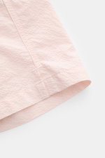 Close-up side view of the hem of 04651/ A trip in a bag Swim shorts 'Mono Seersucker' rose, showing seersucker texture.

<p>Perfect for your next summer holiday: With their design in seersucker look, these swim shorts by 04651/ A TRIP IN A BAG are an eye-