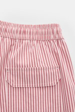 Close-up rear view of 04651/ A trip in a bag Swim shorts rose/burgundy striped showing elasticated waistband, back pocket with hook-and-loop fastener, and vertical stripes.

<p>Perfect for your next summer holiday: With their modern striped pattern, these