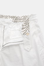 Close-up front view of 04651/ A trip in a bag Badeshorts 'Plain Swim' off-white with zipper, button, elastic waistband featuring contrast stitching and patterned inner lining. Die Badeshorts ‚Plain Swim‘ von 04651/ TRIP IN A BAG aus weicher, schnelltrockn
