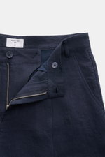 Nahaufnahme, schräge Draufsicht auf offene Percival Leinenshorts navy aus reinem Leinen mit Reißverschluss, Bundknopf, Bundfalte, französischen und paspelierten Taschen.