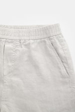 04651/ A trip in a bag Leinenshorts hellgrau in Nahaufnahme von vorne, mit elastischem Bund, französischen Taschen, weichem Leinenstoff und kleinem Weblabel.