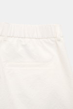 Detailaufnahme der Rückseite der 04651/ A trip in a bag Seersucker-Shorts weiß aus strukturtypischem Microfaser-Seersucker mit Leistentasche, teilelastischem Bund und fixiertem Saumaufschlag, fotografiert aus seitlicher Nahperspektive.