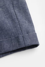 Nahaufnahme der fixierten Saumaufschläge der 04651/ A trip in a bag Shorts navy aus leicht griffigem Leinen-Baumwoll-Denim, fotografiert von unten.