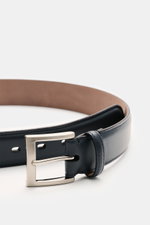 Close-up front-side perspective of Fausto Colato Gürtel navy, crafted from fine smooth leather with a brass pin buckle and single loop, highlighting luxury at the waistband: edles Glattleder, Dornschließe aus Messing, eine Durchzugschlaufe.