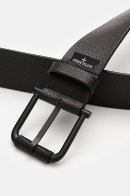 Stone Island Belt black shown from a close-up top angle, featuring elegant cowhide with characteristic grain, matt black pin buckle, one loop, STONE ISLAND embossed logo, small woven label, made in Italy, width 4 cm.
