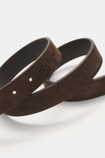 The Row Veloursledergürtel dunkelbraun in Nahaufnahme schräg von oben, edles Veloursleder, Dornschließe, Made in Italy.