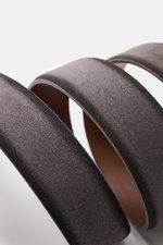 Nahaufnahme des Veneta Cinture Gürtel grau aus geschmeidigem Veloursleder mit leichtem Farbverlauf, fotografiert von oben, Breite 3,5 cm, Dornschließe aus Messing, eine Durchzugschlaufe, Made in Italy.
