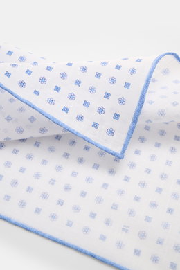 Rosi Collection Linen pocket square 'Fox' white/blue patterned shown from a close-up side angle, featuring pure linen, soft feel, floral print, rolled edges, made in Italy, dimensions 31.5 cm x 31.5 cm.