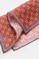 Rosi Collection Leinen-Einstecktuch 'Fox' blau/dunkelbraun/offwhite gemustert, Detailaufnahme schräg von oben, reines Leinen, weicher Griff, floraler Print mit Borte, rollierte Kanten, Made in Italy, Maße 31x31 cm.