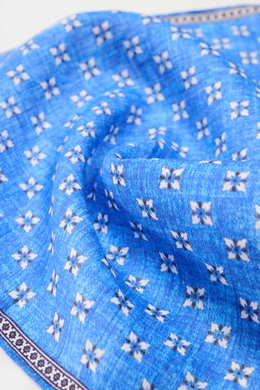 Nahaufnahme aus seitlicher Perspektive des Rosi Collection Leinen-Einstecktuchs 'Fox' rostbraun/blau/offwhite gemustert mit floralem Print, reines Leinen, weicher Griff, rollierte Kanten, Made in Italy, Maße 31x31 cm.
