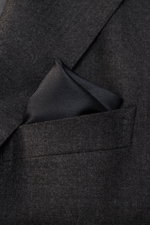 Brunello Cucinelli Silk Pocket Square dark grey in suit breast pocket, photographed close-up from front, smooth pure silk, rolled edges.