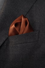 Close-up front view of a rust-colored pocket square in the breast pocket of a dark gray jacket, showcasing the Brunello Cucinelli Seiden-Einstecktuch rauchblau/graublau gepunktet’s fine dotted silk fabric and elegant rollierte Kanten.

Description: <p>D