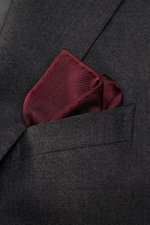 Brunello Cucinelli Silk Pocket Square navy folded in a chest pocket, close-up angled view, pure silk, smooth touch, rolled edges, made in Italy.