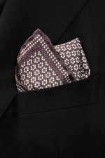 Close-up front view of Brunello Cucinelli Silk pocket square mauve/dark blue pattern tucked into a black jacket pocket, featuring pure silk, smooth feel, graphic micro print, rolled edges, Made in Italy, dimensions approx. 35 cm x 35 cm.