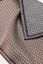 Brunello Cucinelli Silk pocket square dark brown/navy pattern shown close-up from above, pure silk with smooth feel, graphic micro print, rolled edges, Made in Italy, approx. 35 cm x 35 cm.