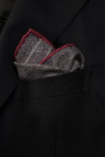 Close-up front-side view of a Brunello Cucinelli Silk pocket square dark grey/light grey/burgundy striped tucked in a black blazer pocket, showing its classic striped pattern with rolled edges.

Description:  
<p>Timeless refinement for sophisticated look