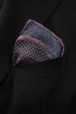 Brunello Cucinelli Silk pocket square navy/dark violet pattern shown close-up from an angled front view in black jacket pocket, pure silk, smooth feel, graphic micro print, rolled edges, Made in Italy, approx. 35 cm x 35 cm.