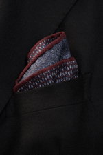 Brunello Cucinelli Silk pocket square dark blue/burgundy pattern shown from close-up front angle in black jacket pocket, pure silk, smooth feel, graphic micro print, rolled edges, Made in Italy, approx. 35 cm x 35 cm.
