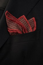 Close-up front view of a Brunello Cucinelli Silk pocket square reddish brown/dark brown pattern in a black jacket pocket, pure silk, smooth feel, graphic micro print, rolled edges, Made in Italy, dimensions approx. 35 cm x 35 cm.