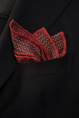 Close-up front view of a Brunello Cucinelli Silk pocket square reddish brown/dark brown pattern in a black jacket pocket, pure silk, smooth feel, graphic micro print, rolled edges, Made in Italy, dimensions approx. 35 cm x 35 cm.