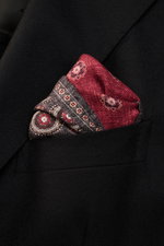 Brunello Cucinelli Silk Pocket Square anthracite/burgundy patterned folded in a blazer pocket, close-up front angle view. Noble accent: The silk pocket square by BRUNELLO CUCINELLI features a subtle medallion pattern that adds a discreet highlight and com