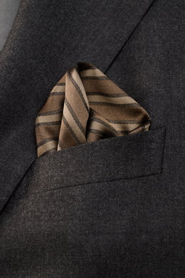 Brunello Cucinelli Silk Pocket Square grey brown/brown striped folded in a dark grey blazer pocket, close-up top view.  
<p>Subtle elegance for stylish appearances: With this noble pocket square in a subdued striped pattern, BRUNELLO CUCINELLI once again 