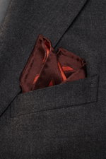 Close-up front view of a Brunello Cucinelli Silk Pocket Square orange/brown striped in a dark grey suit pocket, showcasing smooth silk texture and rolled edges.

Description:  
<p>Subtle elegance for stylish appearances: With this noble pocket square in a