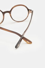 Close-up side and front view of Tom Ford Horn glasses 'Private Collection' brown patterned with genuine buffalo horn round frame and T-shaped details.