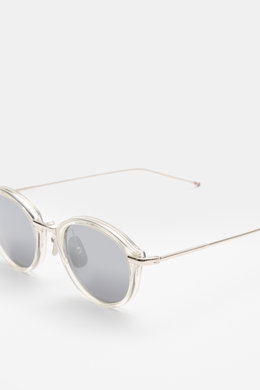 Thom Browne Sonnenbrille silbergrau, runde abgerundete Form, Metallrahmen mit Tricolore-Detail, getönte Gläser, seitliche Nahaufnahme schräg oben.