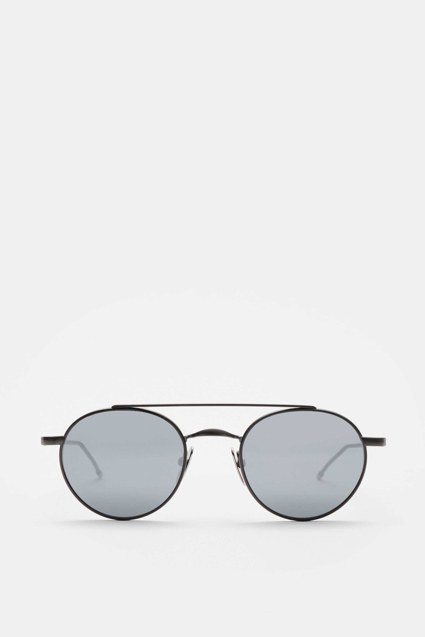 Thom Browne Sonnenbrille dunkelgrau, rund, filigraner Metallrahmen, Tricolore-Detail am Bügel, matte Gläser, 100% UV-Schutz, frontale Ansicht.