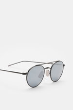 Thom Browne Sonnenbrille dunkelgrau in runder Form, filigraner Metallrahmen, Tricolore-Detail, leicht verspiegelte Gläser, Seitenansicht, 100% UV-Schutz.