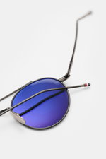 Thom Browne Sonnenbrille dunkelgrau, runde Form mit filigranem Metallrahmen, blaue verspiegelte Gläser, Tricolore-Detail am Bügel, Draufsicht.