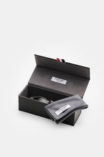 Thom Browne Sonnenbrille grau in klassischer Notched-Bridge-Form mit Schildpatt-Acetatrahmen, getönten Gläsern, 100% UV-Schutz, frontal in offenem Etui.