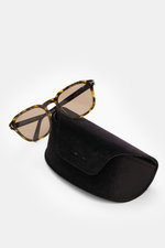 Tom Ford Sonnenbrille 'Avery' grün/dunkelbraun gemustert, eckig mit polariserten Kunststoffgläsern, liegend auf schwarzem Samt-Etui, Seitenansicht.