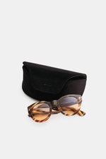 Alt-Tag (124 Zeichen): Tom Ford Sonnenbrille 'Lucinda' braun/hellbraun gemustert, gerundete Silhouette, photochrome Gläser, vor schwarzem Etui, Frontalansicht.