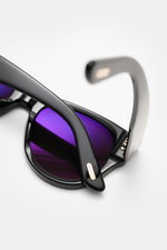 Tom Ford Sonnenbrille 'Burton' schwarz, Makroaufnahme von oben, leicht gerundete Silhouette, Acetat-Rahmen, violette Kunststoffgläser mit 100% UV-Schutz.