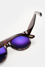 Tom Ford Sonnenbrille 'Burton' dunkelbraun meliert, leicht gerundete Silhouette, Acetat-Rahmen und blaue Gläser, Nahaufnahme von oben.