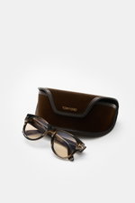 Tom Ford Sonnenbrille 'Burton' schwarz/braun/beige gemustert mit photochromen Gläsern, Acetatrahmen, leicht gerundet, vor Samt-Etui, Frontalansicht.