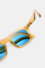 Tom Ford Sonnenbrille 'Dax' gelb/grün, leicht eckiger Acetat-Rahmen, polarisierte blaue Gläser, Nahaufnahme von oben seitlich.