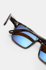 Tom Ford Sonnenbrille 'Calder' dunkelbraun/braun gemustert, eckig, Tortoise-Rahmen, polarisierte blaue Gläser, Acetat, Detailansicht schräg von oben.