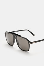 Nahaufnahme der Tom Ford Sonnenbrille 'Autari' schwarz/anthrazit im klassischen Aviator-Stil, mit Acetat-Rahmen und gleichmäßig getönten Kunststoffgläsern, fotografiert aus seitlicher Perspektive.