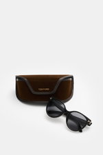 Tom Ford Sonnenbrille 'Tallulah' schwarz im klassischen Papillon-Stil, mit getönten Kunststoffgläsern, Acetat-Rahmen, frontal vor Samt-Hartschalenetui.
