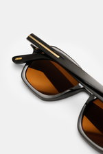 Tom Ford Horn-Sonnenbrille 'Private Collection' dunkelbraun gemustert, leicht eckig, Büffelhornrahmen mit Maserung, goldfarbene Details, braune Gläser, Nahaufnahme seitlich.