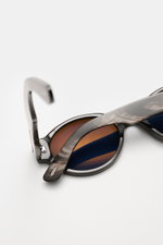 Tom Ford Horn-Sonnenbrille 'Private Collection' schwarz/grau/weiß gemustert, nah von schräg oben, mit Büffelhornrahmen, getönten Gläsern, 'T'-Detail.