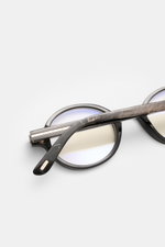 Tom Ford Horn Brille 'Private Collection' schwarz/grau gemustert, runde Form, Büffelhorn, Blaulichtfilter, T-Form Details, seitliche Nahaufnahme.
