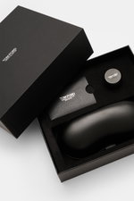 Das Bild zeigt aus der Vogelperspektive die geöffnete Verpackung der Tom Ford Horn Brille 'Private Collection' schwarz/grau gemustert mit Lederetui, Politurset und Putztuch.
